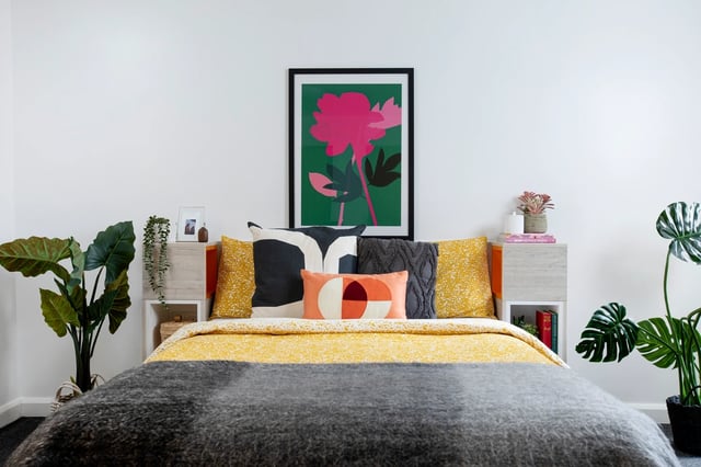 Bed with floral art and plants bedroom at Cambrian Point in Cardiff Student Accommodation
