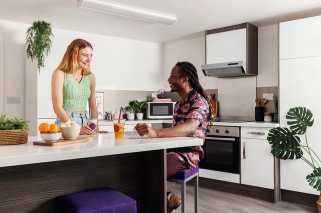 Two students in modern kitchen with snacks kitchen at Hepworth Lodge in Leeds Student Accommodation