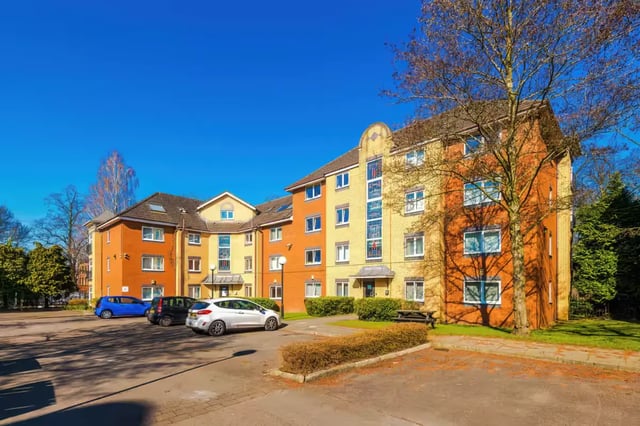 Orange yellow building with cars parking lot exterior at Chancellor's Court in Manchester Student Accommodation