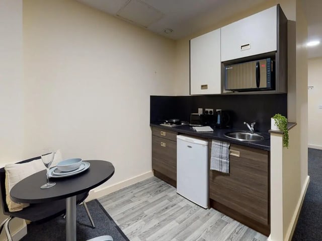 Table plates microwave fridge kettle kitchen area at The Cube in Bolton Student Accommodation
