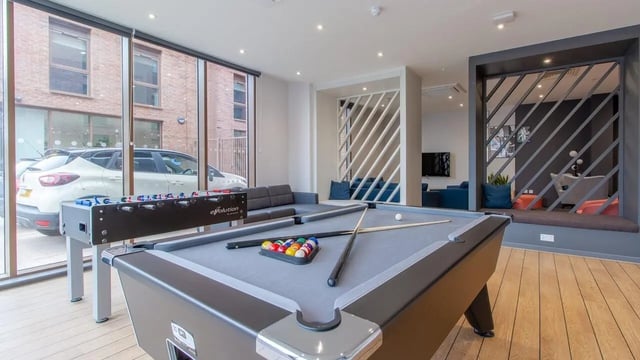 Pool table foosball sofa chairs lounge area living room at Tudor Place in Chester Student Accommodation