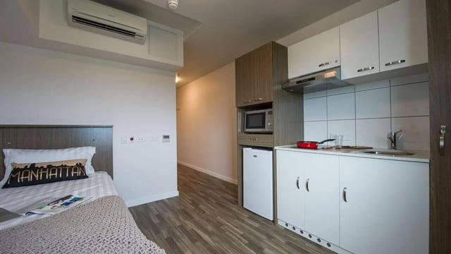 Bed with Manhattan pillow and kitchen studio at UniLodge Darwin in Darwin Student Accommodation