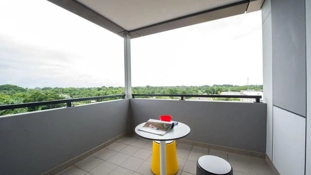 Table with magazines and red cup balcony view exterior at UniLodge Darwin in Darwin Student Accommodation