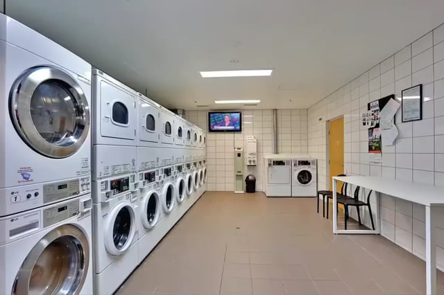 Washing machines dryers television table chairs laundry room at Scape Tribune in Brisbane Student Accommodation