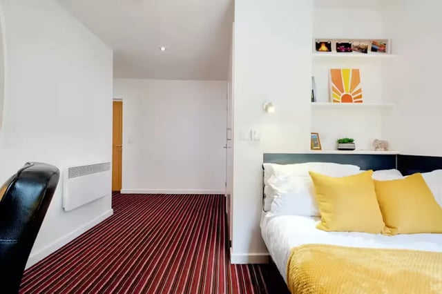 Bed with yellow pillows on striped carpet bedroom at Brookland Road in Leicester Student Accommodation