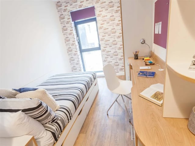 Bed with striped bedding desk with lamp chair bedroom at Roman House Newcastle in Newcastle Upon Tyne Student Accommodation