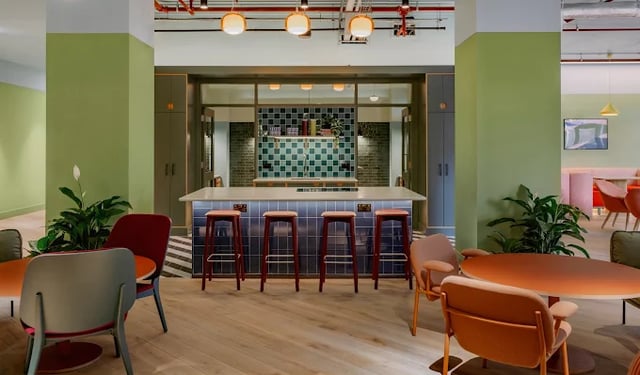 Bar stools at counter with kitchen area and seating living room at Scape Leeds in Leeds Student Accommodation