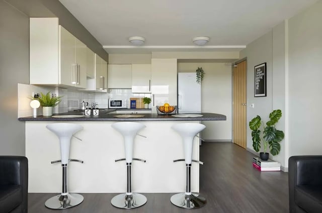 White bar stools and modern kitchen with fridge Kitchen at Discovery Heights in Plymouth Student Accommodation