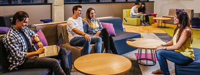 Students on sofas with laptops and tables lounge area at Student One Adelaide Street in Brisbane Student Accommodation