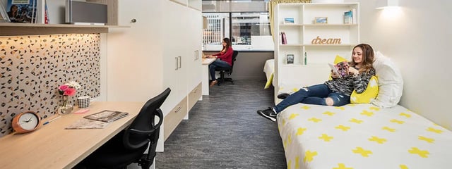 Desk bed and shelving with people student accommodation bedroom at Student One Adelaide Street in Brisbane Student Accommodation