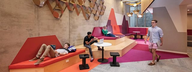 Students relaxing on tiered seating with laptops living area at Student One Wharf Street in Brisbane Student Accommodation