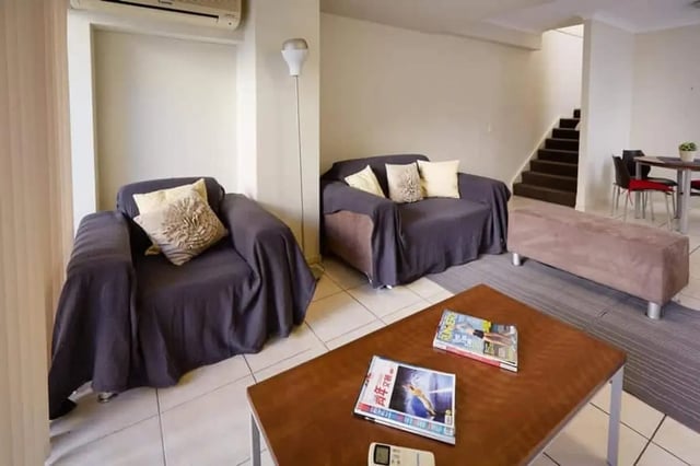 Two sofas and armchair with magazines living room at Genesis 1 in Brisbane Student Accommodation