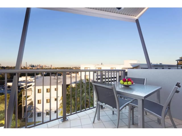 Table and chairs on balcony overlooking cityscape exterior at Altitude Taringa in Brisbane Student Accommodation
