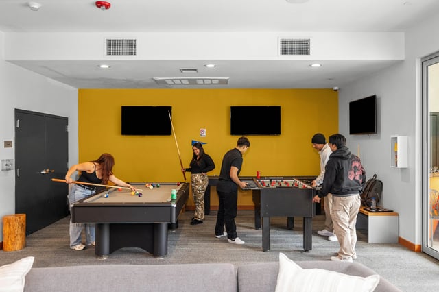 Students play pool and foosball in recreation room at The Glen in San Bernardino Student Accommodation