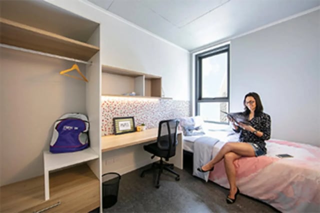 Closet bed desk and woman reading bedroom at Student One Elizabeth Street in Brisbane Student Accommodation