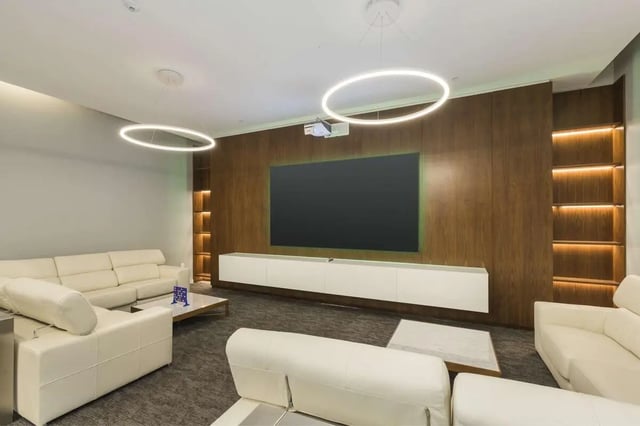 White sofas large television projector built-in shelves living room at 24 Fifty at University Park in Denver Student Accommodation
