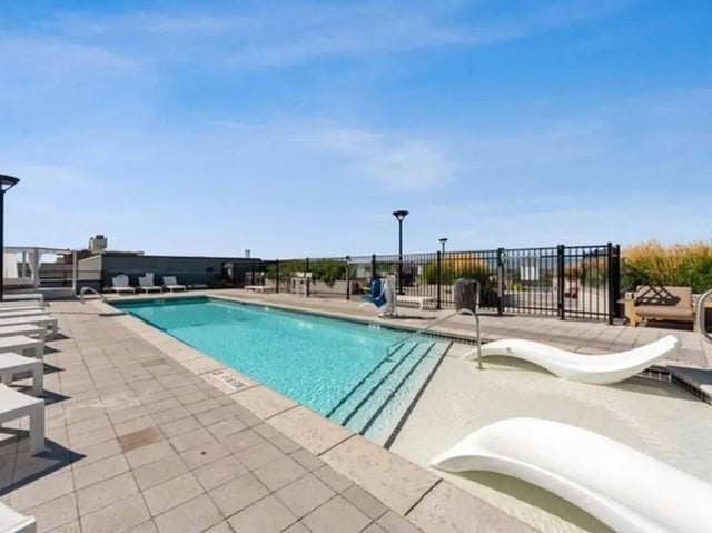 Pool with lounge chairs and white chaises pool area at 24 Fifty at University Park in Denver Student Accommodation