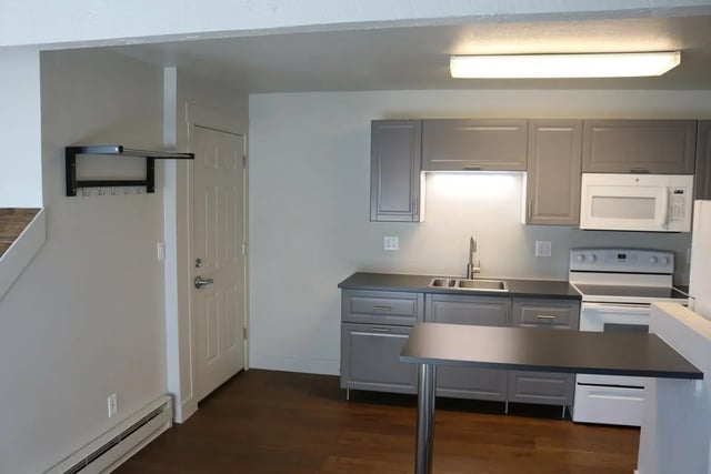 Kitchen cabinets sink microwave stove and table kitchen at Tiltn Hiltn Apartments in Eagle Student Accommodation