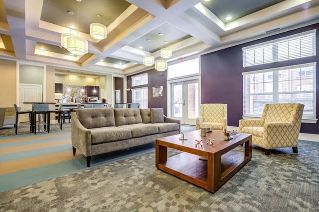 Sofa chairs coffee table and kitchen area lounge at The Union Charlotte in Charlotte Student Accommodation