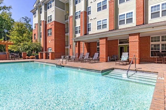 Pool with lounge chairs and building exterior Exterior at The Union Charlotte in Charlotte Student Accommodation