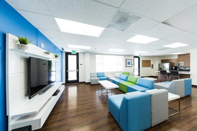 Modern lounge with colorful sofas and kitchen living room at Cerca in San Diego Student Accommodation