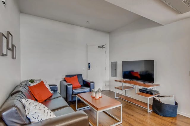 Brown leather sofa and accent chair living room at Cerca in San Diego Student Accommodation