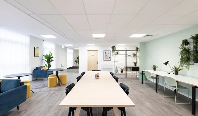Long table sofas shelves study desks plants living room at The Cavendish in Winchester Student Accommodation