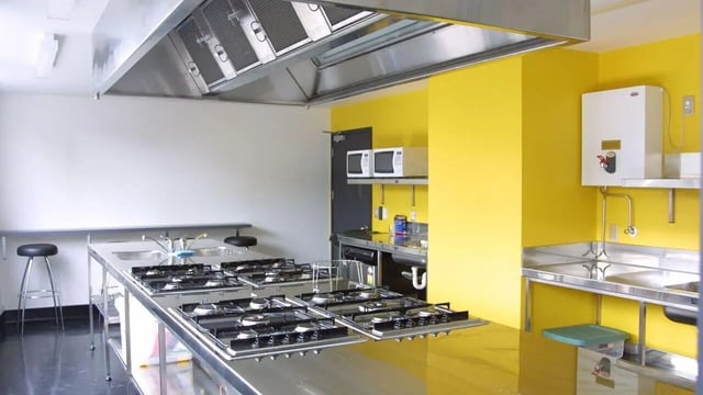 Commercial kitchen with multiple stoves and sinks at Student Living Auckland in Auckland Student Accommodation