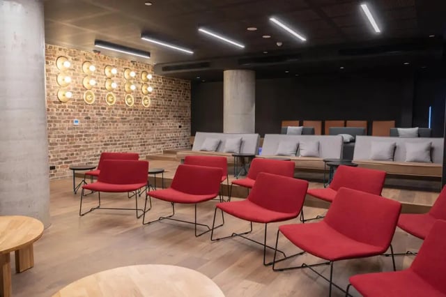 Red chairs brick wall lounge seating living room at Perth Central in Perth Student Accommodation
