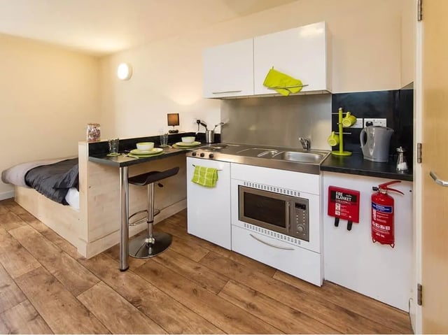 Bed kitchen unit with microwave and fire safety equipment studio at Optima in Loughborough Student Accommodation