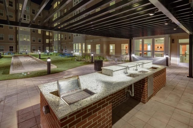 Outdoor kitchen with grill sinks and bocce court Exterior at Landmark Apartment in College Park Student Accommodation