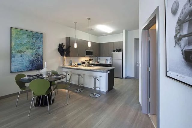 Dining table and kitchen island with stools living room at Ion at the Ballpark in Birmingham Student Accommodation
