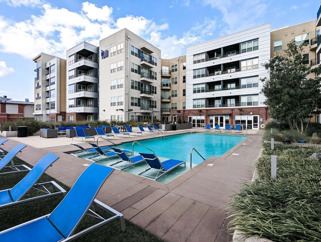Blue loungers by large swimming pool exterior at Ion at the Ballpark in Birmingham Student Accommodation