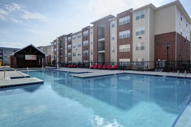 Pool lounge chairs and building exterior resort at The Reserve at Greensboro in Greensboro Student Accommodation