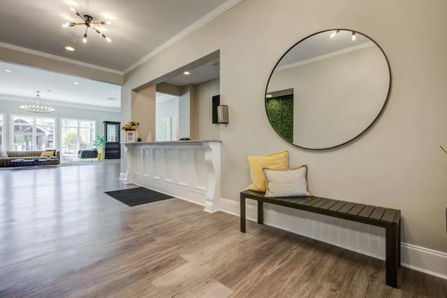 Reception area with bench mirror and plants lobby at The Reserve at Greensboro in Greensboro Student Accommodation