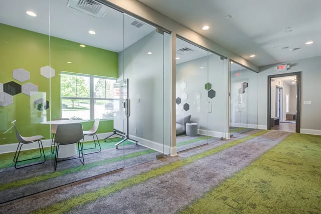 Glass study rooms with hexagonal wall decor communal area at The Reserve at Greensboro in Greensboro Student Accommodation