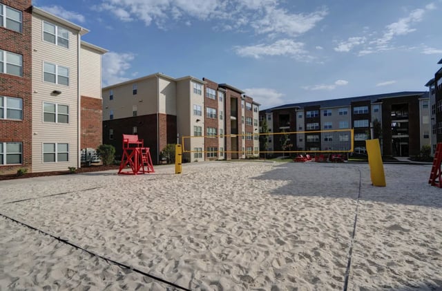 Volleyball court with buildings and red lifeguard chair playing area at The Reserve at Greensboro in Greensboro Student Accommodation