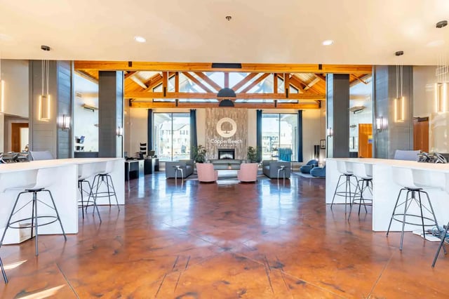 Bar tables white chairs fireplace lounge living room at Copper Beech Townhomes - San Marcos in San Marcos Student Accommodation