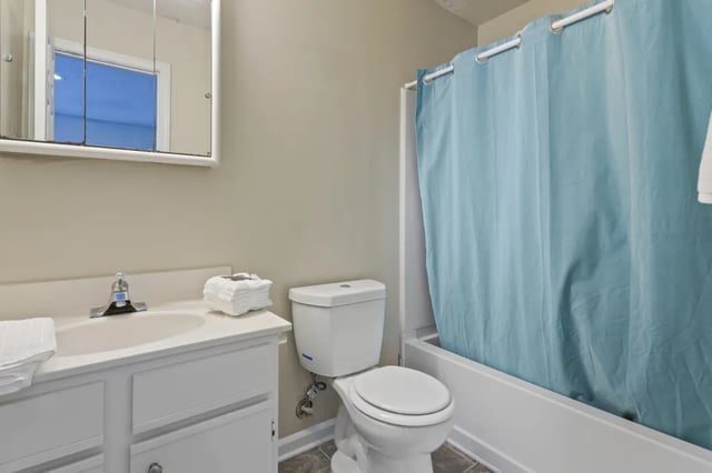 Sink toilet and blue shower curtain bathroom at West Quad Greensboro in Greensboro Student Accommodation