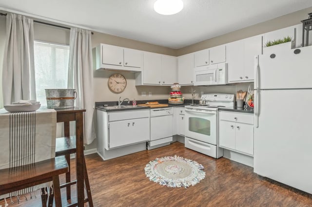White cabinets sink stove refrigerator kitchen rug kitchen at West Quad Greensboro in Greensboro Student Accommodation