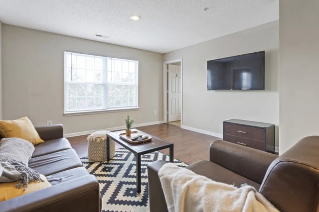 Brown couches coffee table patterned rug living room at West Quad Greensboro in Greensboro Student Accommodation