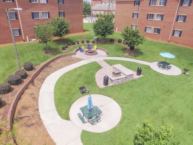 Fire pit picnic tables grills exterior at West Quad Greensboro in Greensboro Student Accommodation