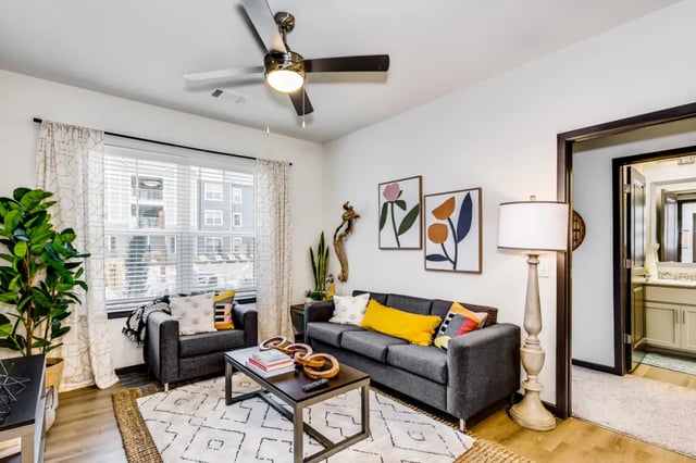 Sofa chairs rug coffee table framed art living room at Altitude at Wichita in Wichita Student Accommodation