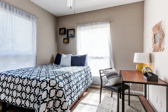 Bed with patterned duvet study desk chair bedroom at Cambridge @ Southern - The Palms in Statesboro Student Accommodation