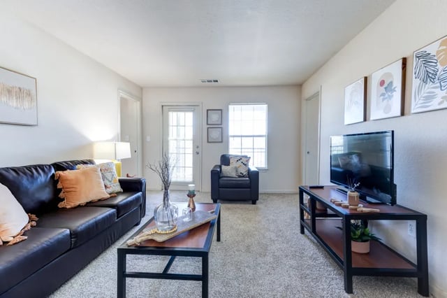 Black leather couch coffee table and television living room at Cambridge @ Southern - The Palms in Statesboro Student Accommodation
