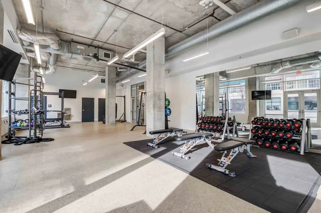 Dumbbell racks weight benches gym equipment workout area gym at LUX on Capitol in Indianapolis Student Accommodation