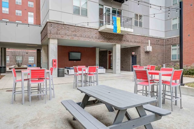 Outdoor seating with tables chairs and picnic table common area at LUX on Capitol in Indianapolis Student Accommodation