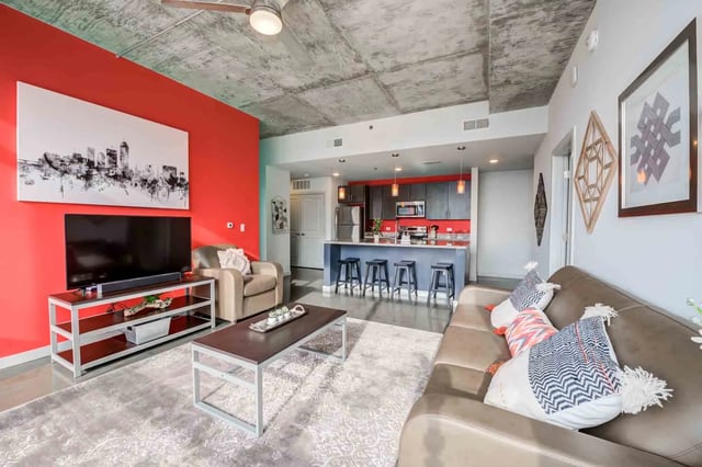 Sofa kitchen island bar stools and TV living room at LUX on Capitol in Indianapolis Student Accommodation