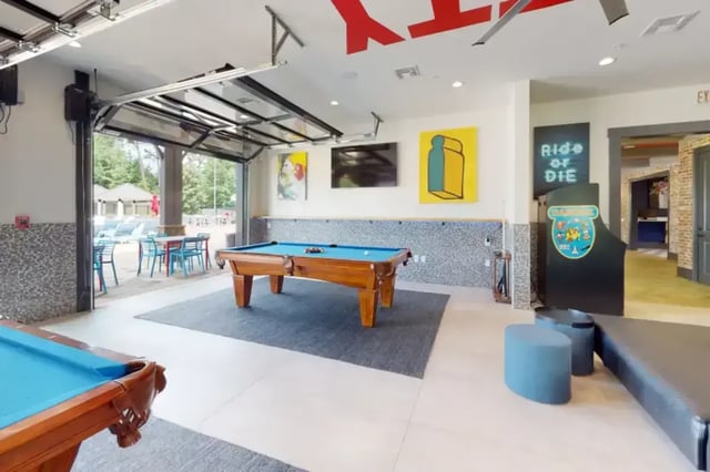 Pool table arcade machine and lounge seating game room at College Town Oxford in Oxford Student Accommodation