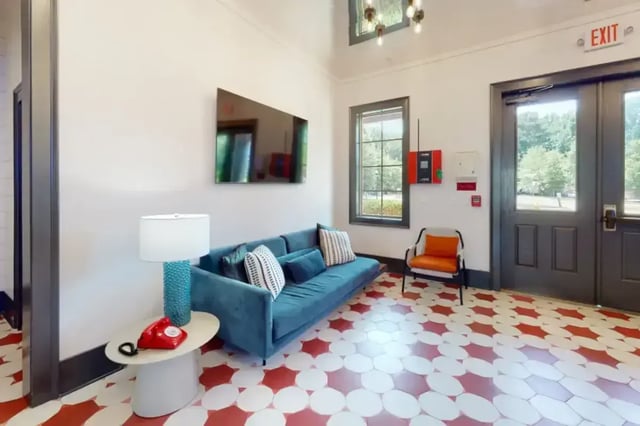 Blue couch red phone lamp and chair living room at College Town Oxford in Oxford Student Accommodation